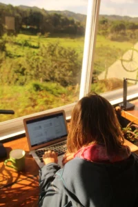 Person working by the window with a nature view in the coworking space