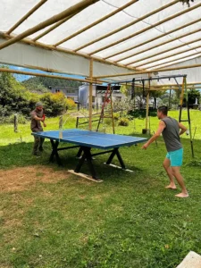 Two people playing ping-pong outdoors