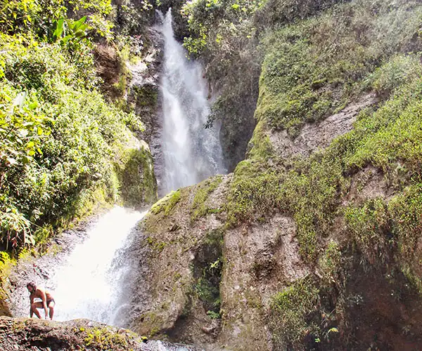 Salto de los Monos waterfall surrounded by lush green hills near Jericó, Colombia.
